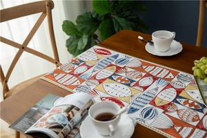 Detail of chenille table runner featuring colorful abstract fish patterns and tassel trim