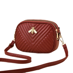 Deep red V-quilted small crossbody camera bag with golden bee icon and dual zippers