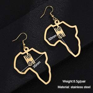 Detailed macro view of gold-plated hollow African map earrings with intricate scroll patterns