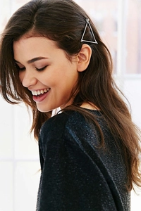 Detail of a geometric silver triangle hair clip worn on a woman's side profile