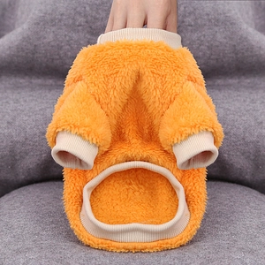 Detail of warm orange fleece pet sweater showing soft texture and ribbed cuffs