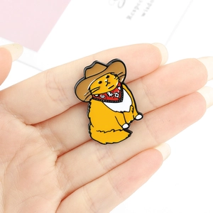 Cute cartoon ginger cat cowboy enamel pin badge accessory held in hand on white background