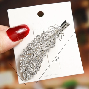 Detailed view of silver feather hair clip with rhinestones and 6.5cm size markings