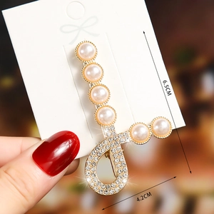 Detailed view of elegant gold pearl hair clip with rhinestones measuring 6.5cm by 4.2cm
