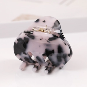 Close-up of acetic acid hair claw clip featuring black and white marble patterns