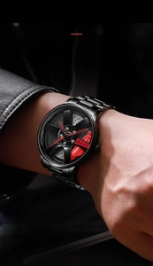 Close-up of black sport watch with car wheel rim dial and red brake caliper detail