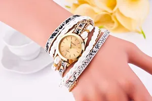 Macro detail of white braided faux leather watch with snakeskin pattern and gold chain