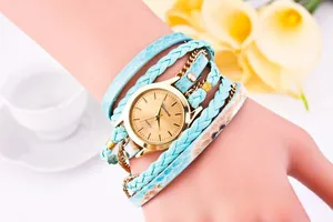 Detail of a blue woven multi-layer wrap bracelet watch with a gold round dial for women