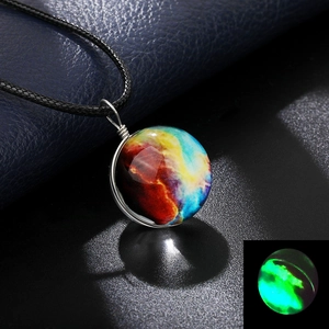 Macro shot of glass galaxy orb pendant showing glowing luminous effect in the dark