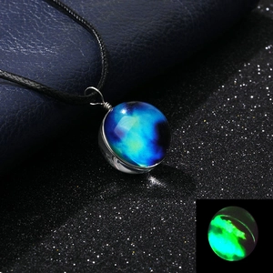 Detailed view of handmade galaxy glass ball necklace with glowing green nebula effect
