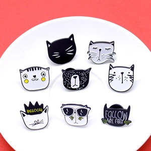 Close-up of eight cute cartoon cat enamel pins arranged on a white plate over red background