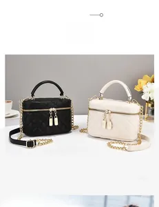 Détail du sac boîte matelassé en cuir avec double zip et pendentif de serrure