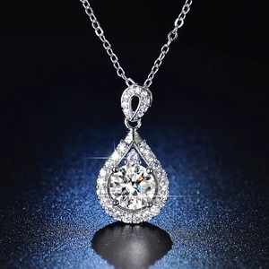 Macro shot of silver halo drop pendant necklace with sparkling round cut moissanite stone