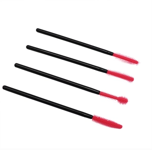 Disposable silicone eyelash brushes set with pink tips and black handles on white background