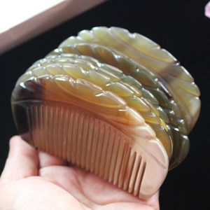 Macro shot of semi-transparent brown yak horn comb with carved textures and fine teeth