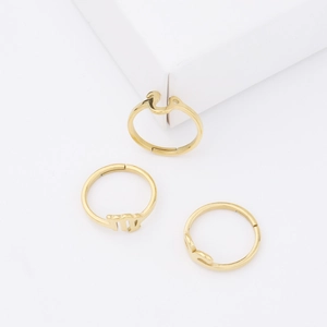 Three-piece stackable mirror finish 18k gold stainless steel zodiac rings on white pedestals