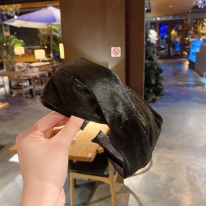 Dettaglio di un cerchietto largo vintage in velluto nero con nodo centrale