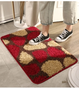 Detail view of plush absorbent door mat with red and brown geometric circle patterns