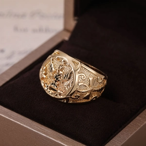 Detailed macro view of vintage gold eagle signet ring with intricate floral carvings