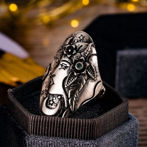Primer plano de anillo vintage plateado con grabado de diosa y piedra preciosa verde