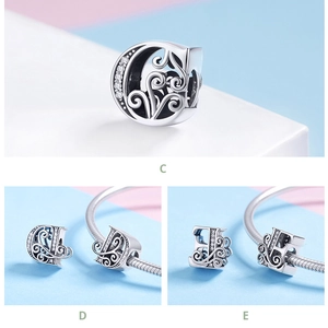 Detailed view of silver letter C, D, E charms with zircon inlays and swirl texture