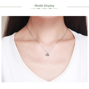 Model wearing sterling silver necklace with a heart-shaped zircon pendant on white top