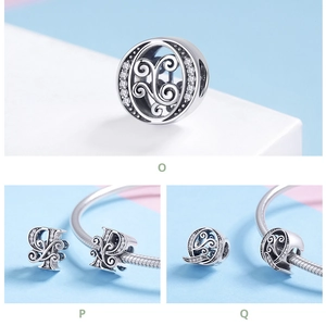 Detailed view of silver charm beads O, P, Q with filigree swirls and sparkling zircons
