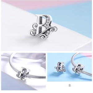 Detailed view of sterling silver letter B charm with sparkling zircon and filigree pattern