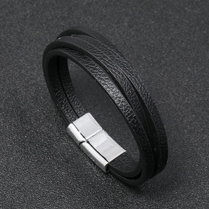 Primer plano de pulsera de cuero negro multicapa con cierre magnético plateado seguro