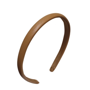 Minimalist brown leather headband with fine lychee texture on white background
