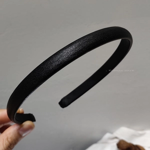 Detailansicht der feinen Lederstruktur und des schlanken Designs dieses schwarzen Haarreifs