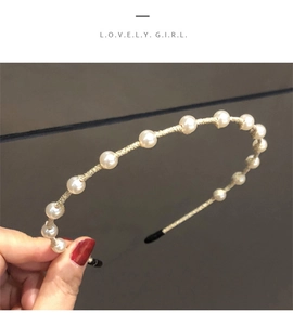 Detailed view of beige woven headband with white pearls and slim metal base
