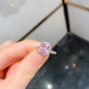 Macro shot of silver ring with radiant cut pink gemstone and halo pavé diamond accents