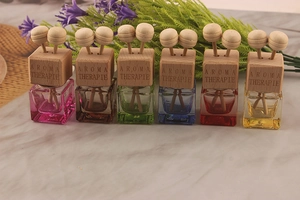 Macro shot of colorful glass car perfume bottles with wooden caps and diffuser balls