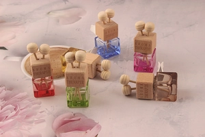 Close-up of square glass car perfume bottles with colorful liquids and wood caps