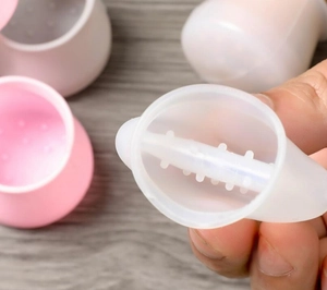 Close-up of silicone chair leg protectors with anti-slip inner texture in pink and white