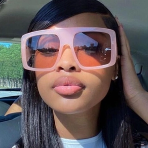 Trendy oversized square sunglasses with nude frames and gradient lenses worn by a model
