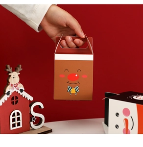 Close-up of a festive Christmas reindeer gift box held against a red background