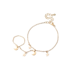 Minimalist gold star and moon pendant finger bracelet set on a clean white background