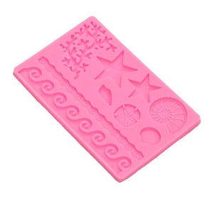 Pink silicone mold for sea world cake toppers including starfish and shells on white base