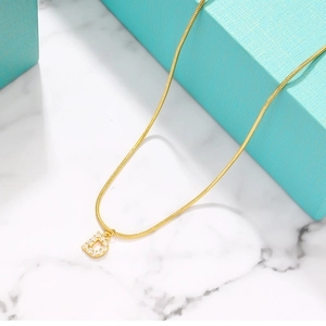 Detailed close-up of golden letter D pendant with crystals on a snake chain