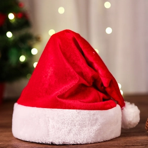 Classic red plush Christmas hat with white fur trim and pompom against festive lights