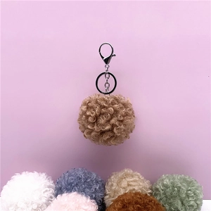 Detailed view showing multiple color options for cute curly fur pom pom keychains and bag charms