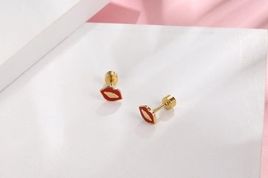 Macro shot of titanium steel red lip earrings with gold plating and screw back design