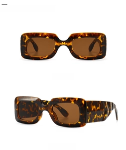 Detail view of leopard tortoise shell sunglasses with thick rectangular frames and tan lenses