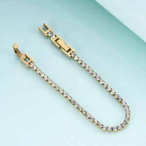 Detailed macro view of the double fold-over clasp on a gold-plated zircon tennis bracelet