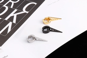 Vue détaillée de boucles d'oreilles triangulaires en acier or, noir et argenté