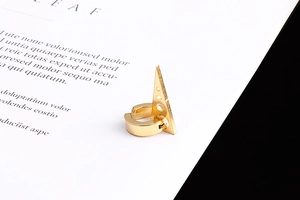 Détail d'un ear cuff triangle doré poli avec un design géométrique à clip