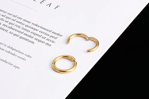 Detail of golden stainless steel hoop earrings showing open and closed hinge mechanisms