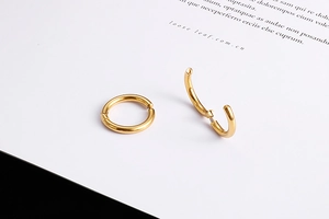 Detailed view of golden stainless steel clip-on earrings in open and closed positions